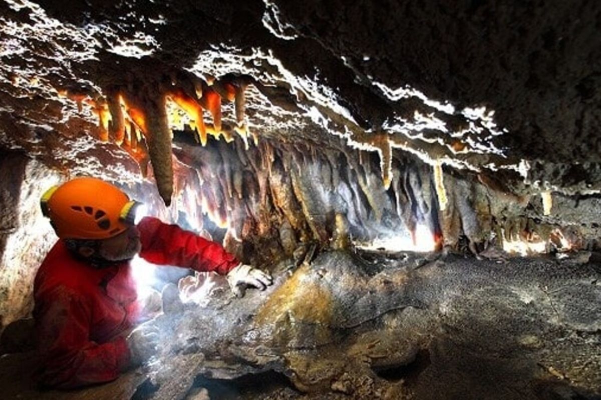 Unesco, carsismo nelle evaporiti e grotte dell'Appennino settentrionale - veduta interna della grotta con stalattiti con speleologo 